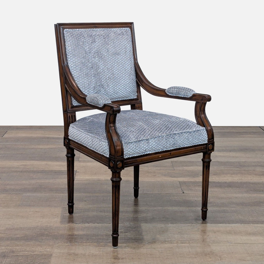 Three-quarter view of a wooden chair with blue upholstery.