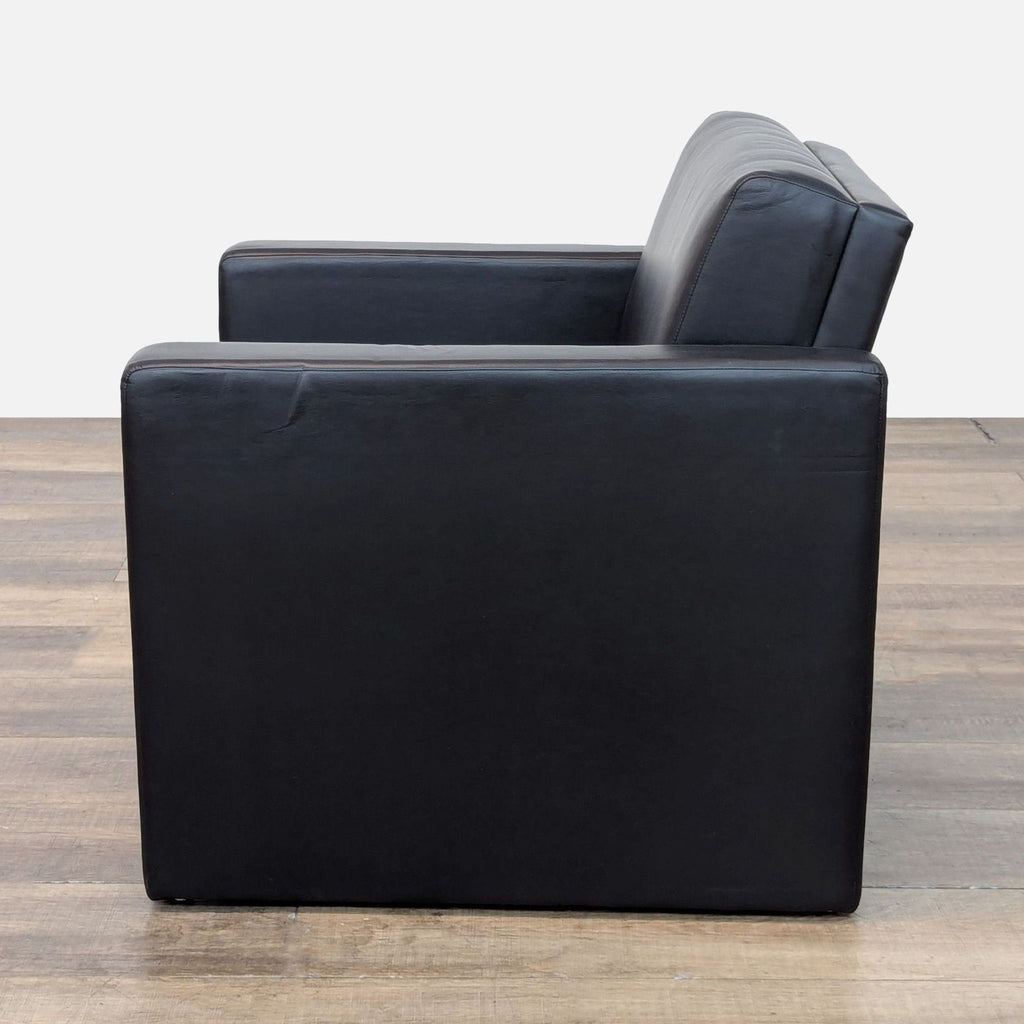 Side profile of a Pennant lounge chair in black faux leather.
