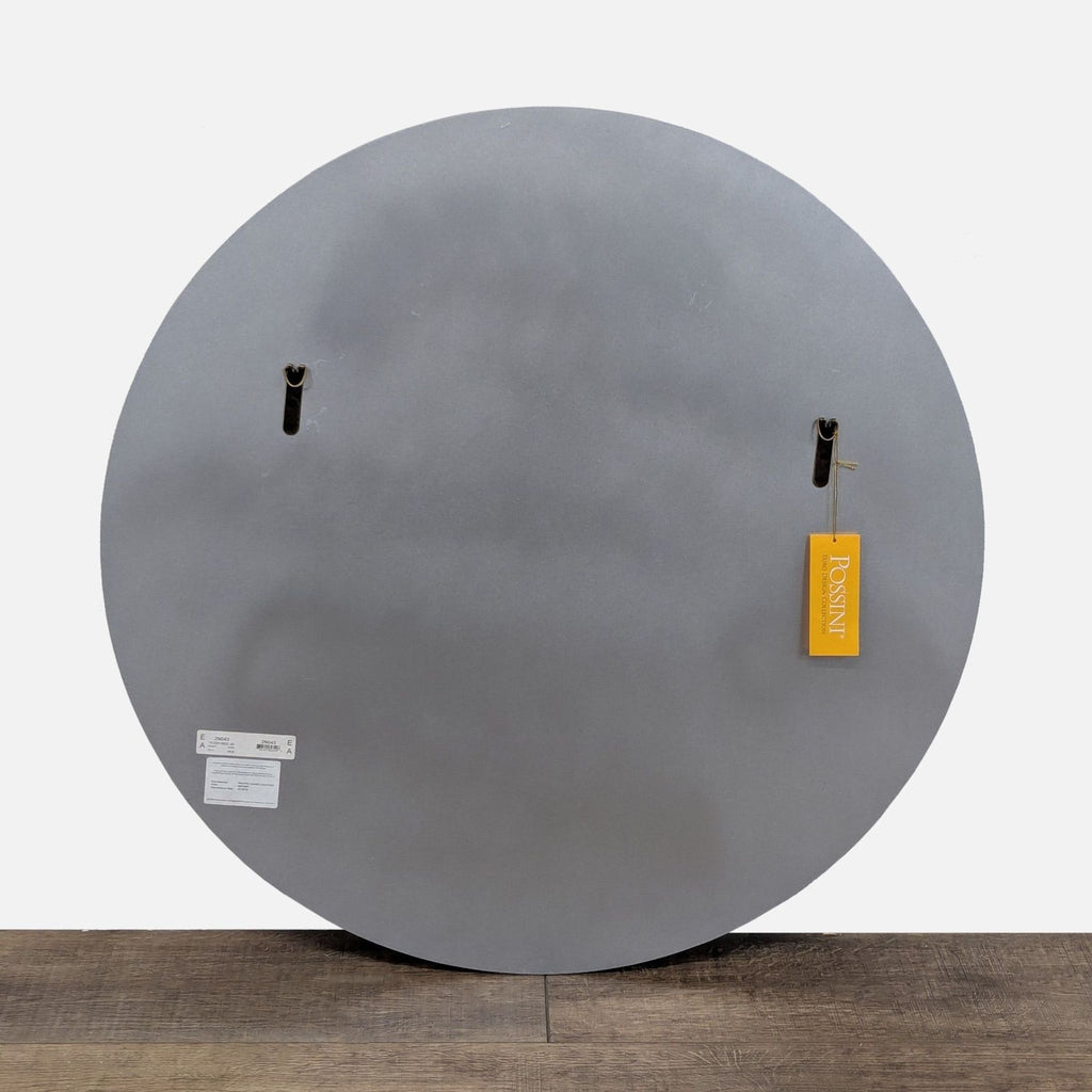 Back of a Possini mirror showing mounting hardware and brand tag against a wooden floor.