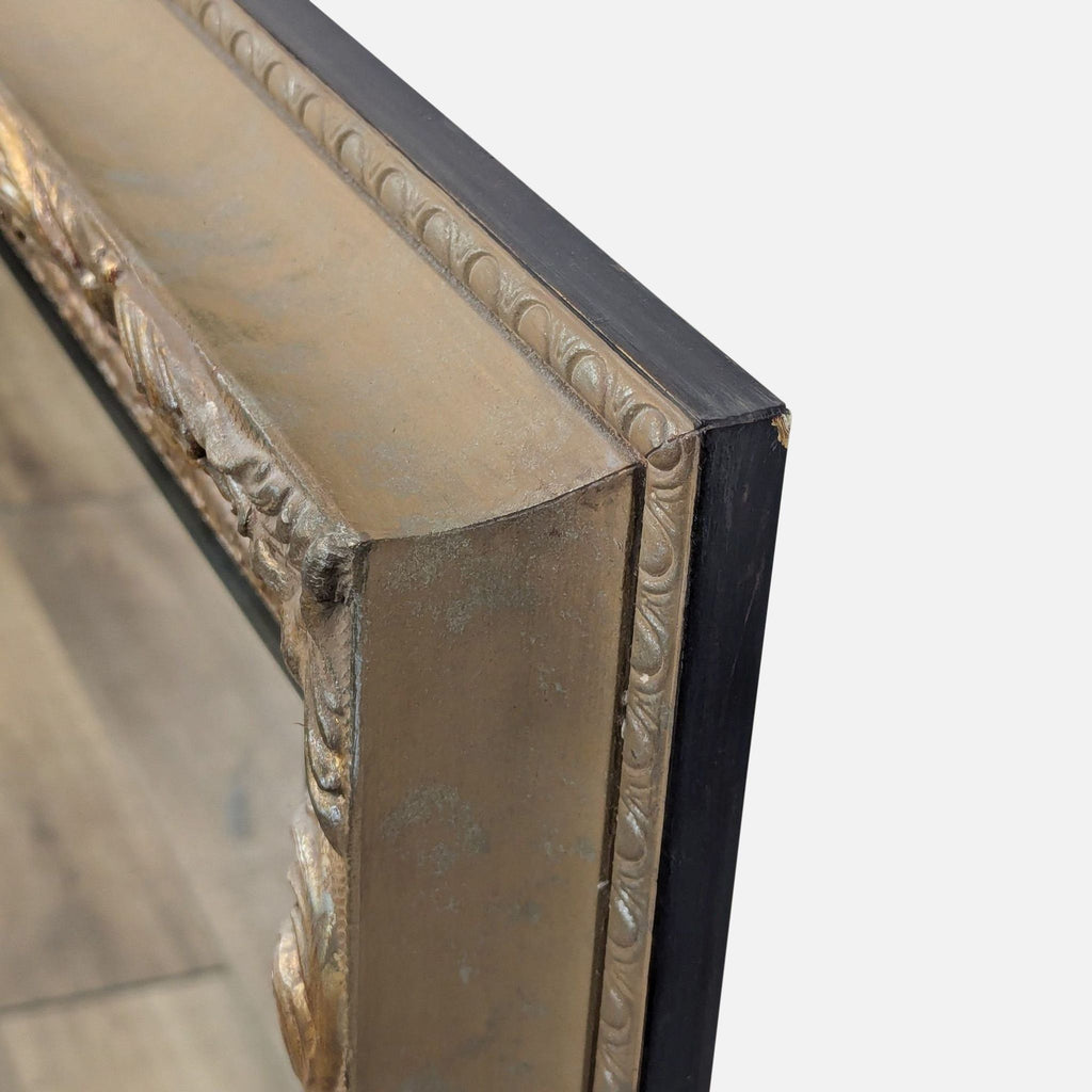 Detailed close-up of the ornate gold design on the Reperch mirror frame.