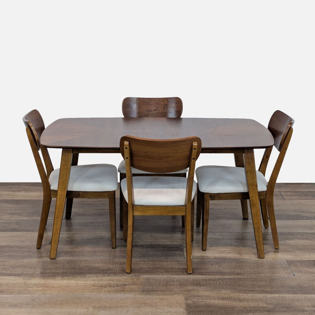 Mid-century modern dining set with wooden table and four cushioned chairs.