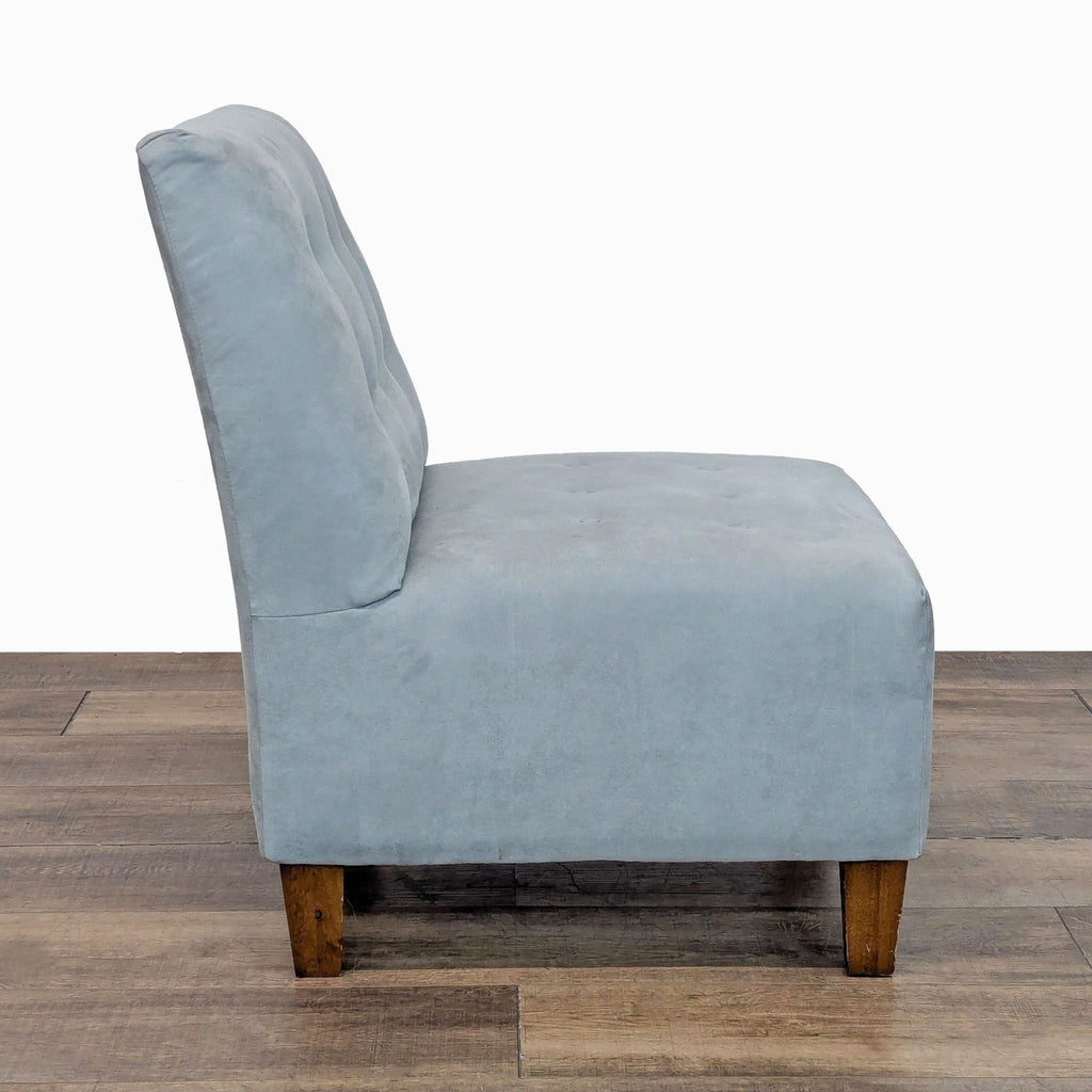Side view of a lounge chair with tufted fabric and tapered wood legs.