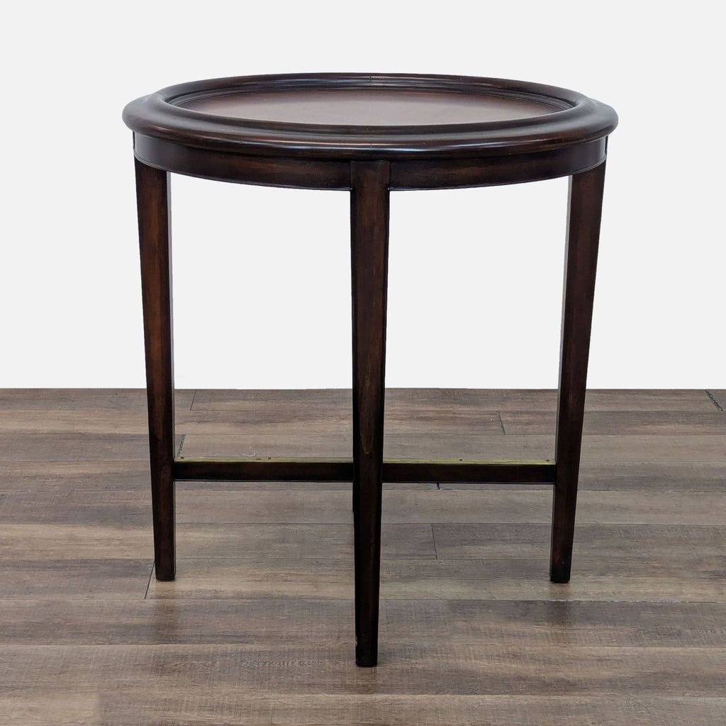 Elegant round console table by Woodbridge Furniture, featuring crossed legs.