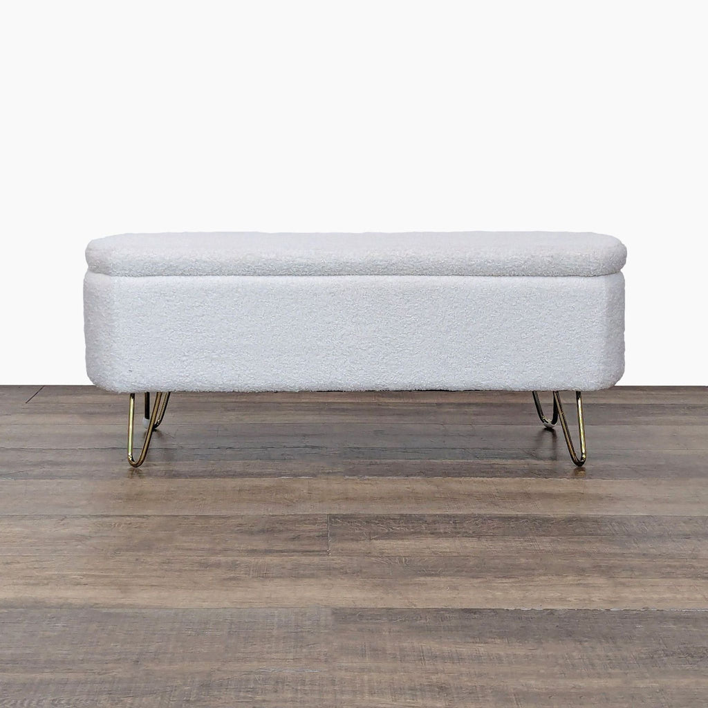 Reperch ottoman with white upholstery and gold hairpin legs on wooden floor.