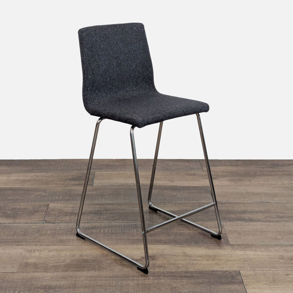Side view of a gray stool with sleek metal frame, Reperch brand.