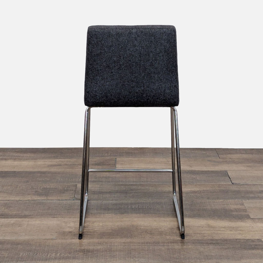 Back view of Reperch stool, featuring gray fabric and chrome legs.