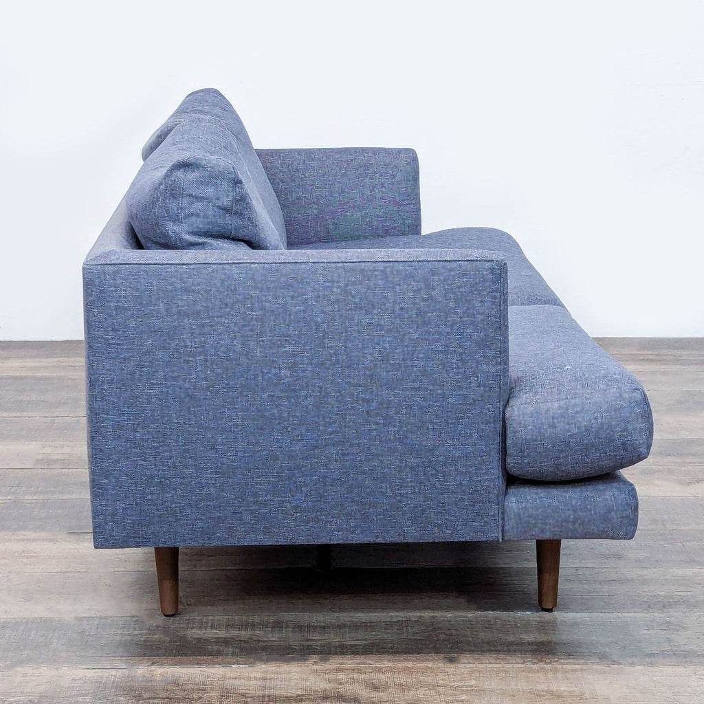 Side view of blue loveseat from Article, featuring slender arms.