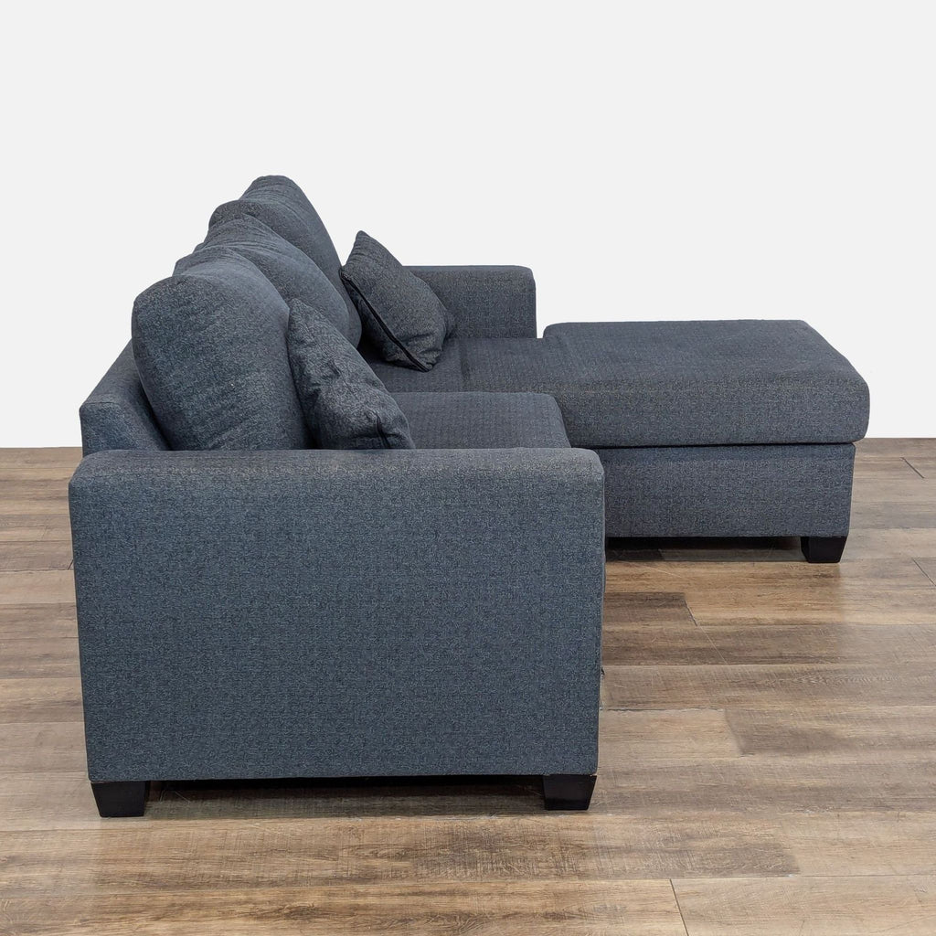 Side view of a modular sectional sofa, showcasing its reversible chaise and track arms.  