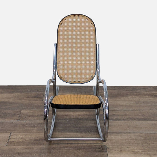 Front view of a vintage rocking chair with chrome frame and rattan seat.