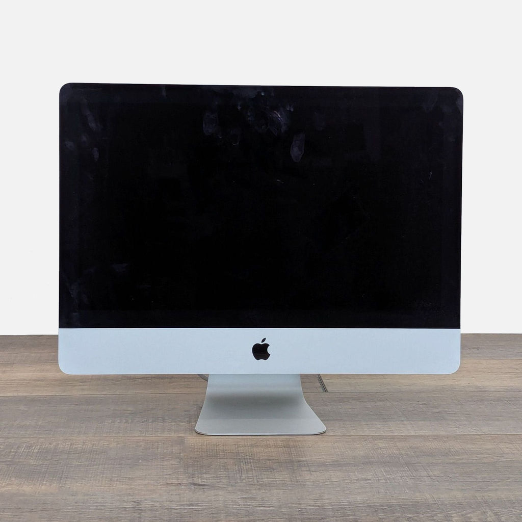 1. Front view of a 27" Apple iMac Retina Display Monitor with a black screen on a wooden desk.