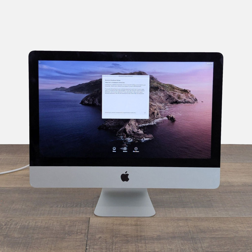 2. Apple 27" iMac Retina Display showing setup screen, showcasing vibrant Retina display on desk.