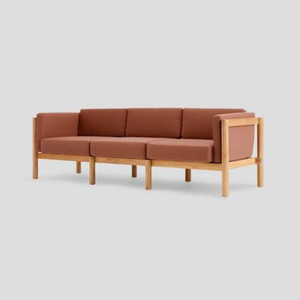 3. Angled view of a three-seat sofa with teak wood frame and rust Sunbrella cushions, designed for durability.