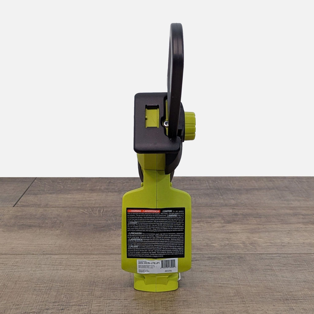 1. Rear view of a Sun Joe 24V cordless mini chainsaw, showing warning label and slim, compact design.