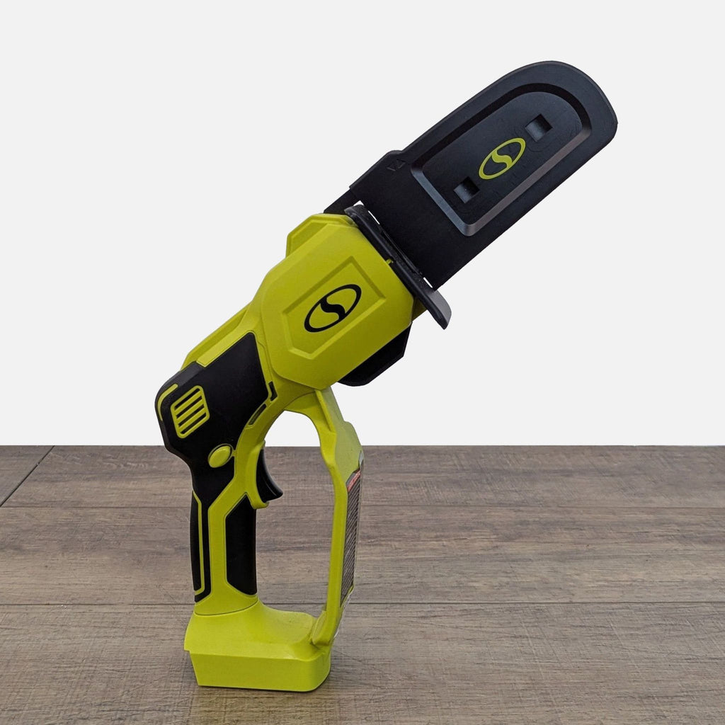 2. Side profile of the Sun Joe mini chainsaw with its black and green body, battery base, and protective bar cover.