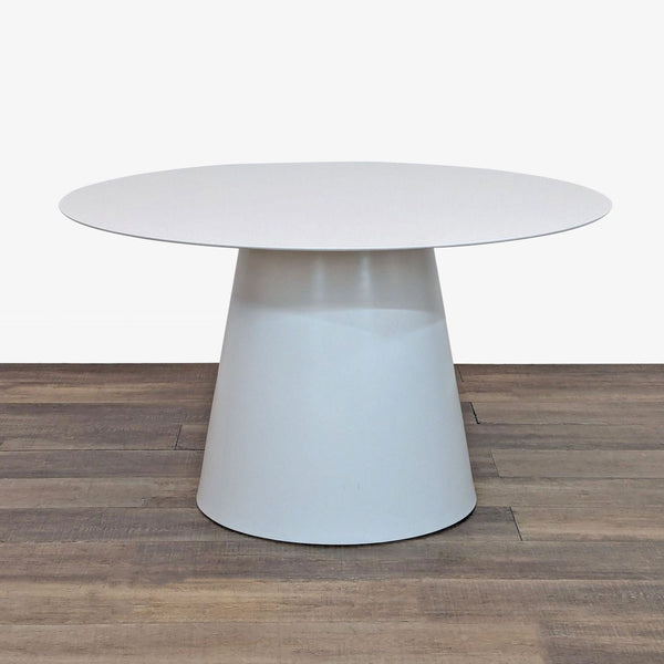 Round metal dining table by Blu Dot on a wooden floor.