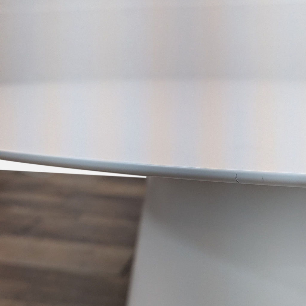 2. Close-up of the Reperch metal table edge, displaying its smooth, light-colored finish and detail.