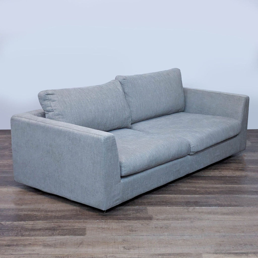 Angled view of a gray Relax Form loveseat featuring removable cushions.