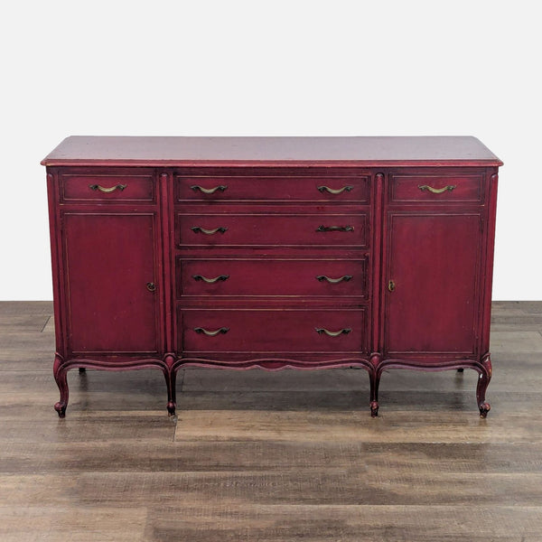 Antique red sideboard with six drawers and ornate handles.