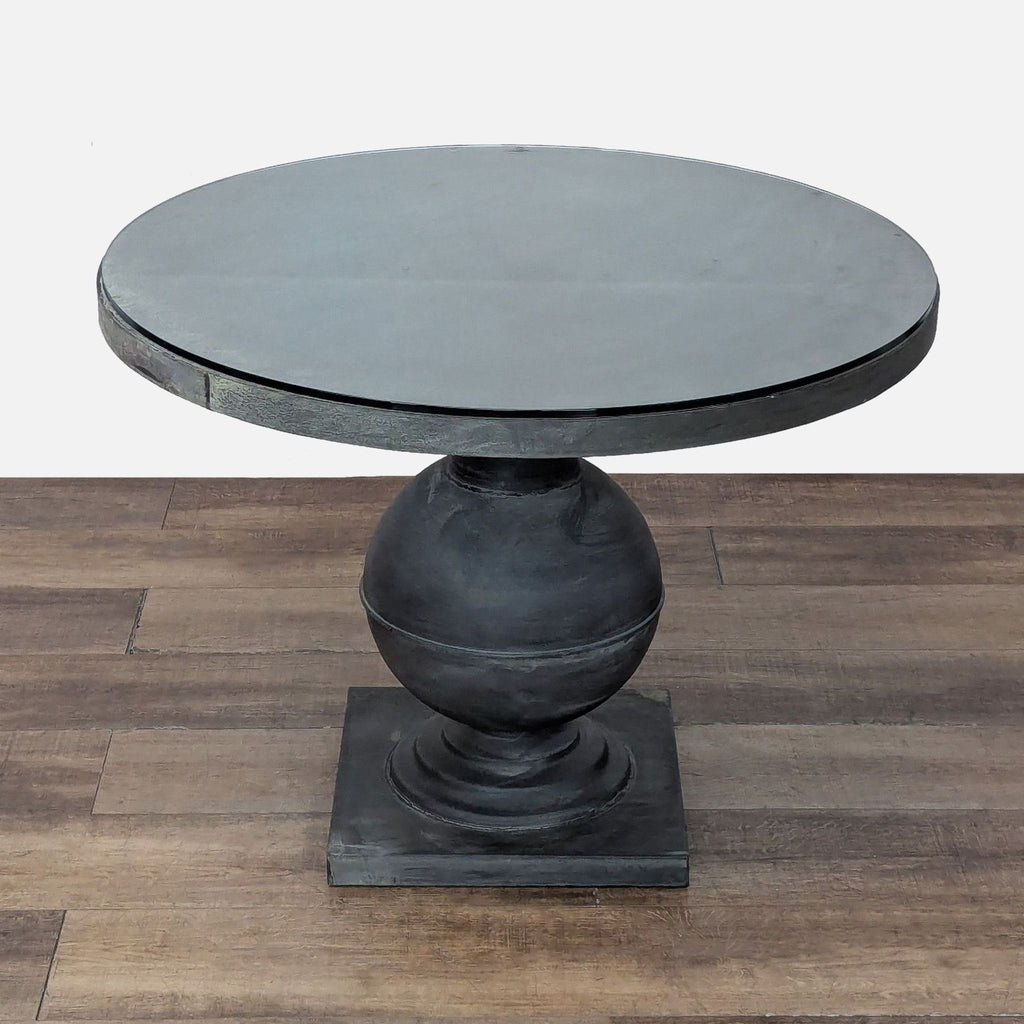 3. Contemporary glass-top dining table by Reperch with a round design and sculpted base for indoor or outdoor spaces.