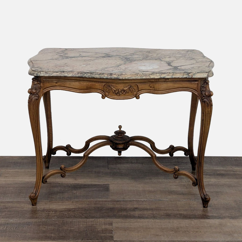 Reperch side table with ornate legs and a marble top on wooden floor.