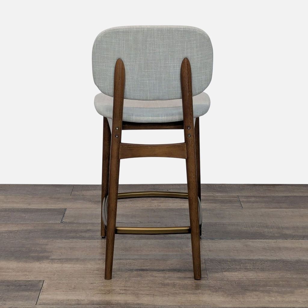 Back view of stool with fabric upholstery and bent wood seat and back, supported by rubber wood legs.