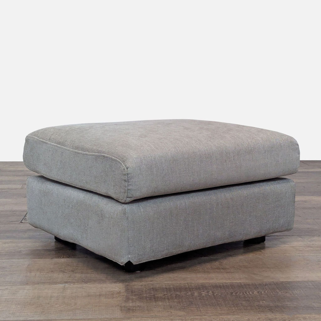 Stylish gray ottoman from Relax Form on a wooden surface.  