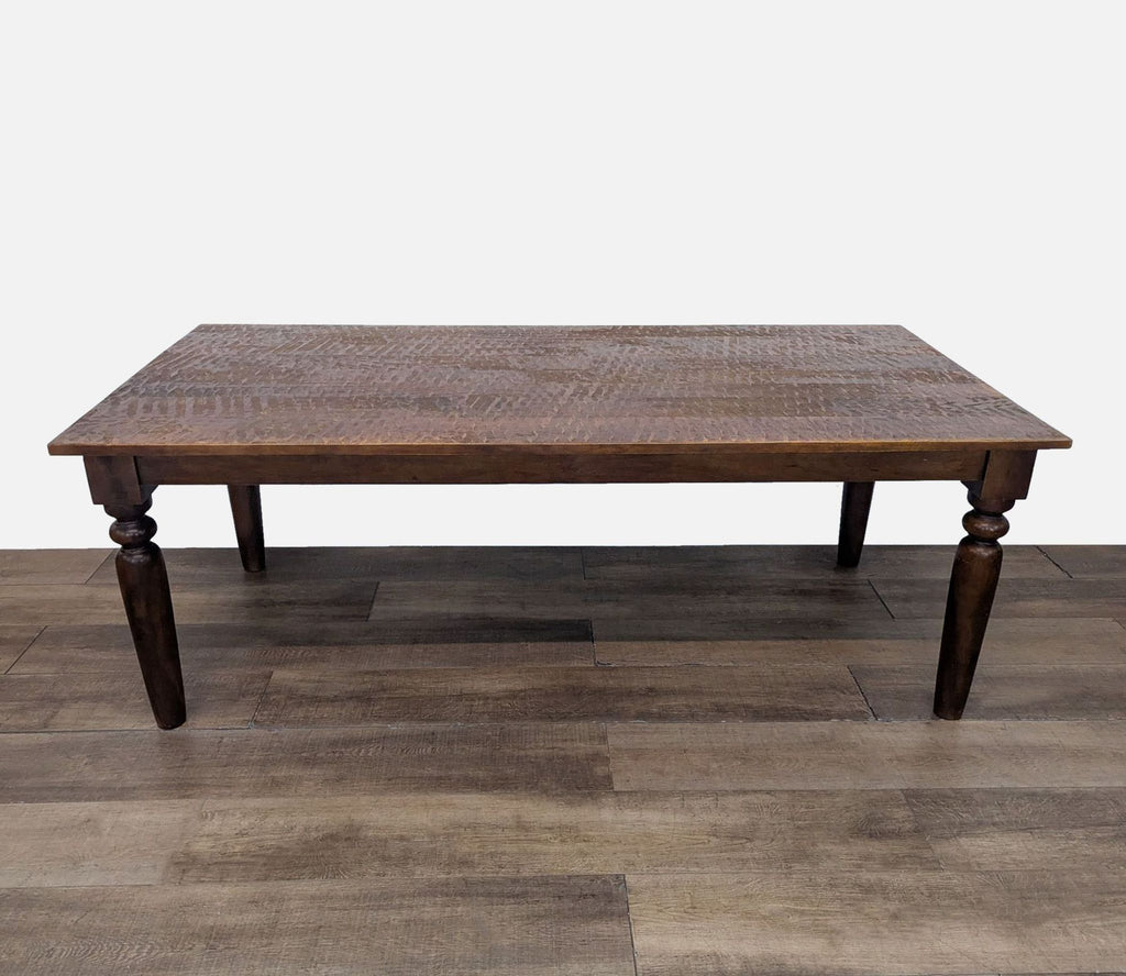 2. Solid wood dining table with detailed turned legs from World Market, shown alone on wooden flooring.