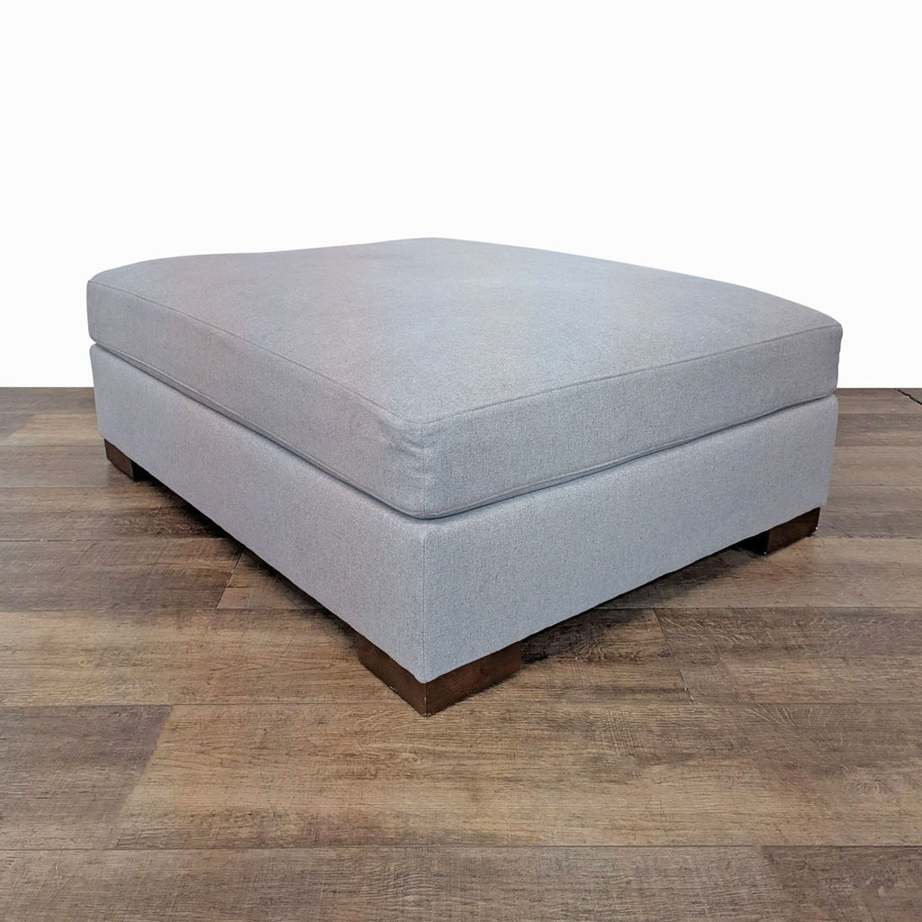 Side angle of Rejuvenation Felton ottoman with cashmere flannel fabric on wood floor.