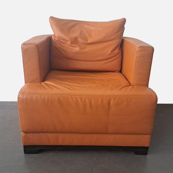 1. Natuzzi lounge chair with curved back, track arms, and orange leather upholstery, viewed from the front.
