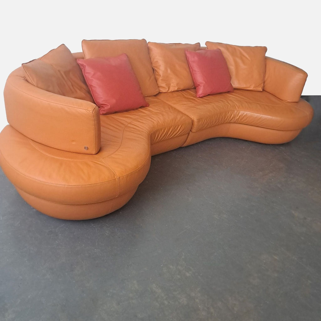 2. Side angle of a Natuzzi semicircular leather sofa featuring plush cushions and reddish accent pillows.