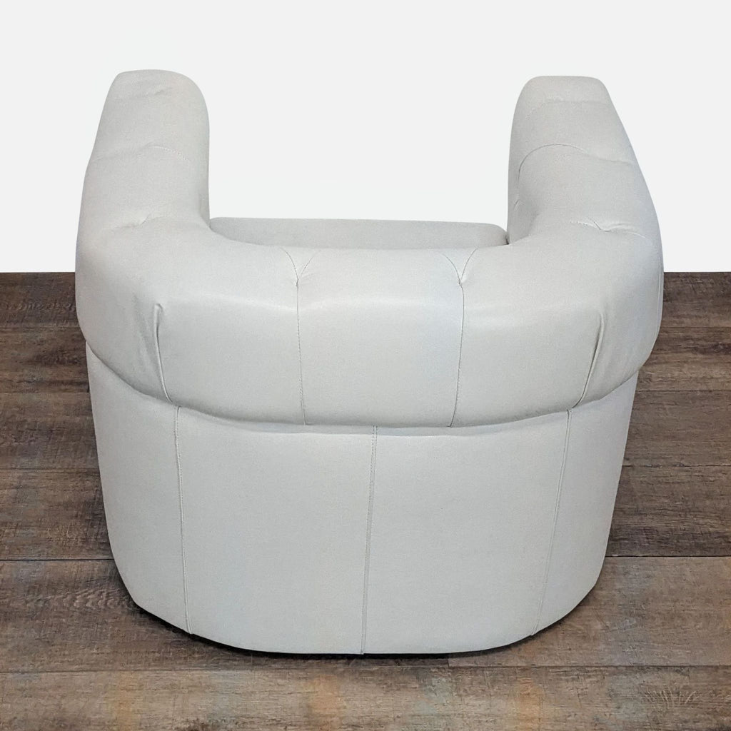 3. Angled back view of West Elm lounge chair showing rounded back and armrests in white leather.