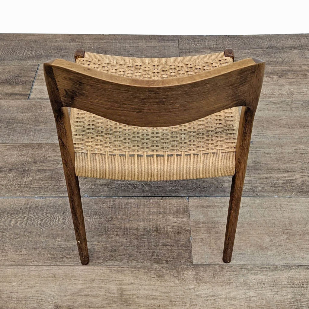 Rear view of the Reperch side chair, highlighting the curved wood backrest and woven paper cord seat.