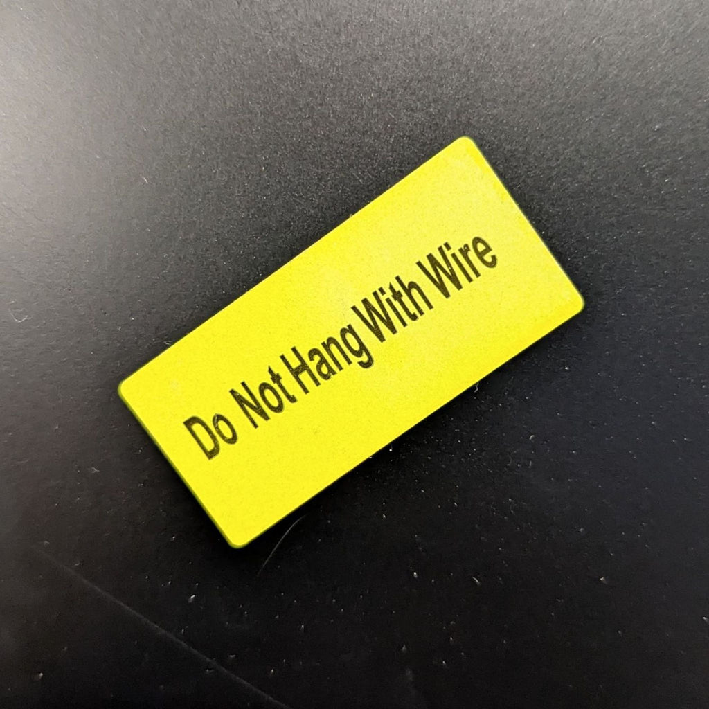 Close-up of yellow label reading "Do Not Hang With Wire."