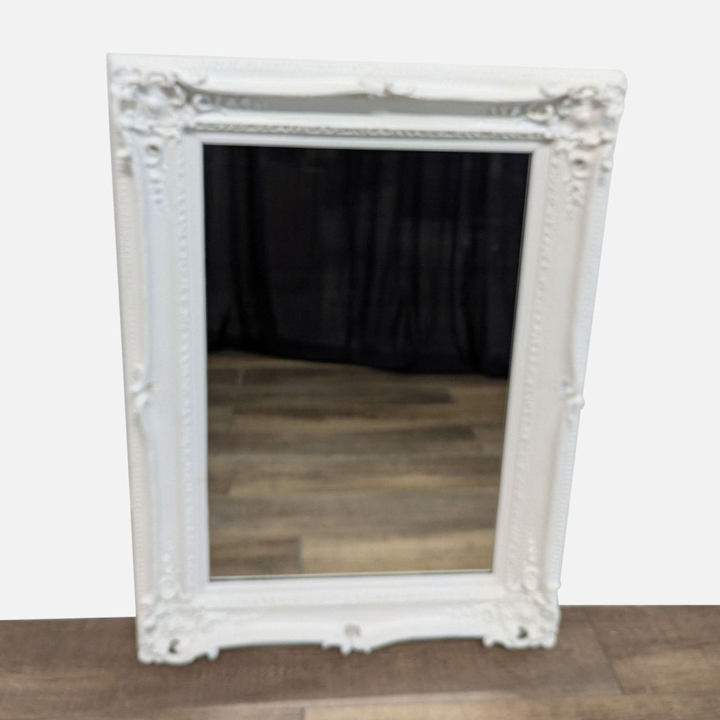 Elegant white Reperch mirror with ornate frame and wooden floor reflection.