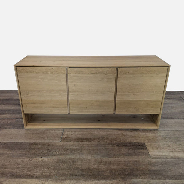 Reperch wooden sideboard with three closed doors on a wooden floor.