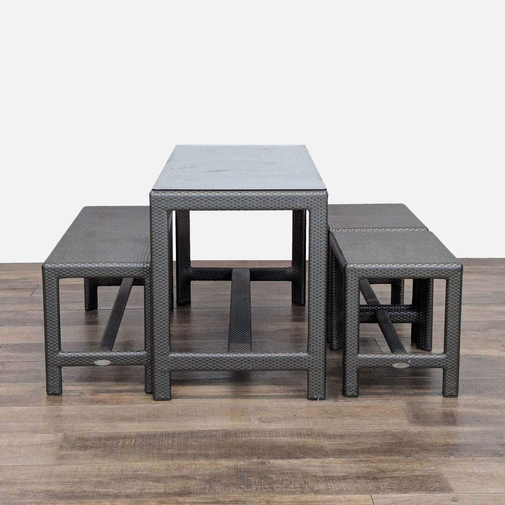 3. Modern rattan outdoor dining set includes protective glass table, one large, and two small benches by Dedon.