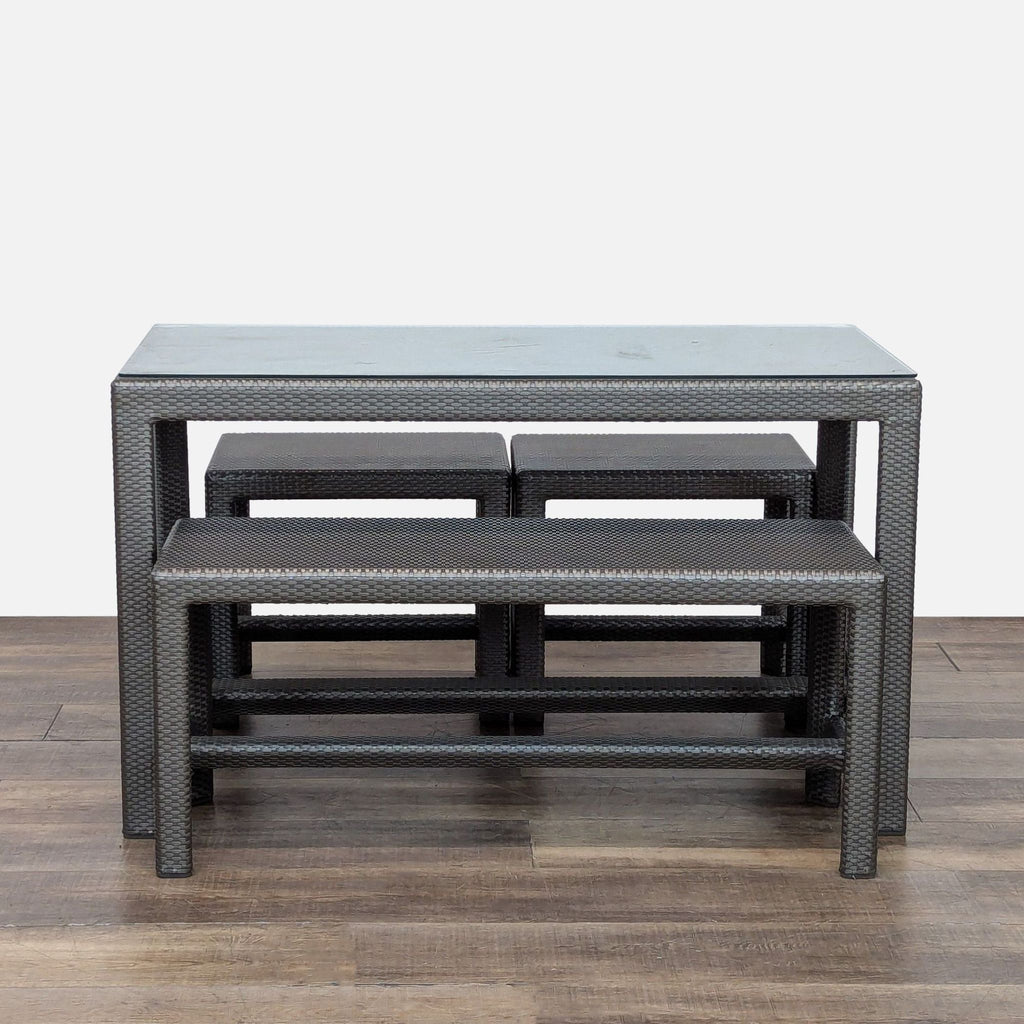 1. Outdoor dining set by Dedon with glass-top table, one large bench, and two small benches in woven rattan.