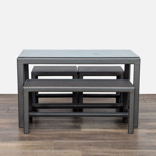 1. Outdoor dining set by Dedon with glass-top table, one large bench, and two small benches in woven rattan.