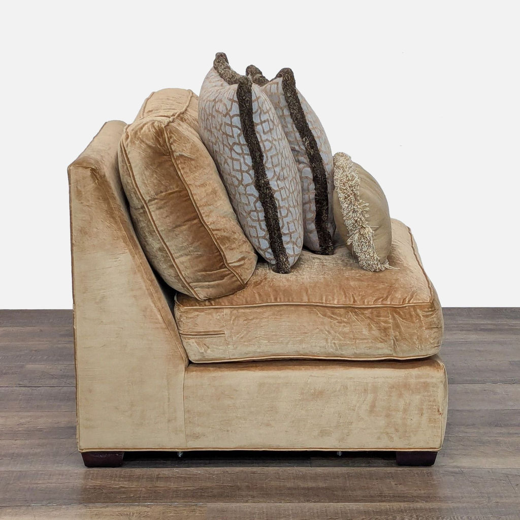 2. Side view of gold-tone armless lounge chair by Reperch, featuring textured upholstery and three pillows.