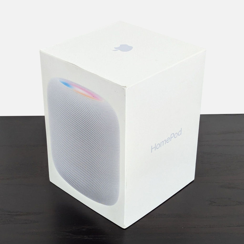 Original Apple HomePod box in white, featuring product image and branding, placed on a dark surface.  