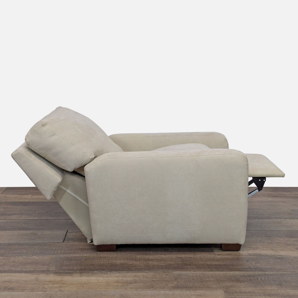2. Side view of a soft beige American Upholstery push back recliner partly extended, showing wood feet.  