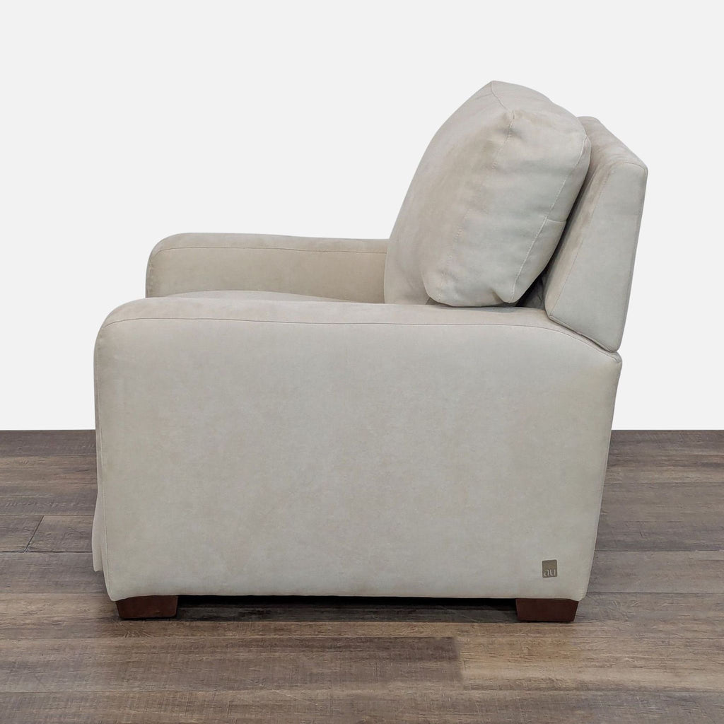 3. Side profile of an American Upholstery lounge chair with soft neutral fabric and wooden feet.