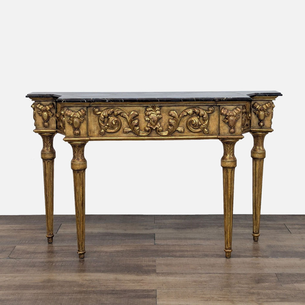 1. Ornate gilded console table with carved details, fluted legs, and a dark marble top, front view.