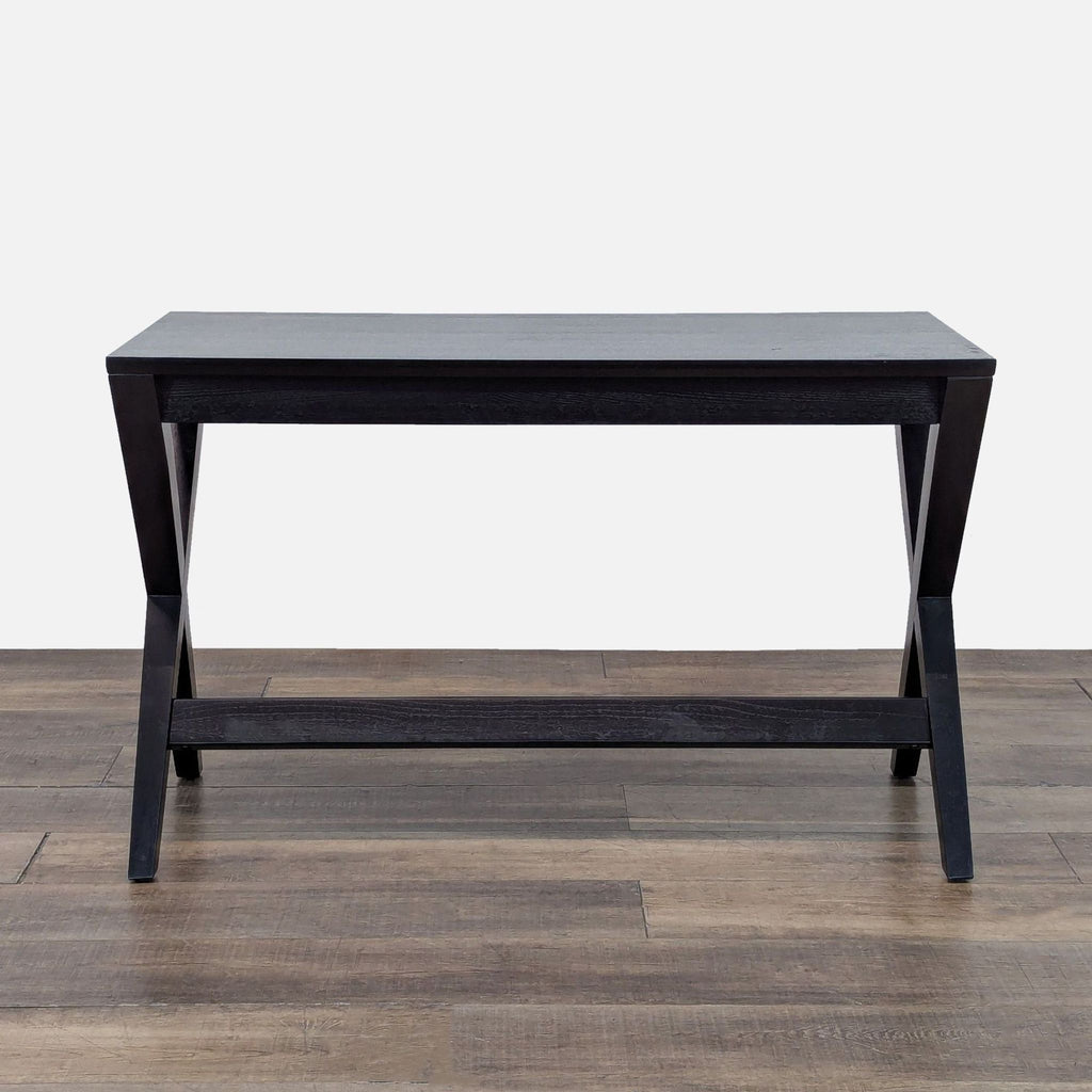 1. Reperch desk with crossed black legs and a minimalist, slim top, seen from the front.