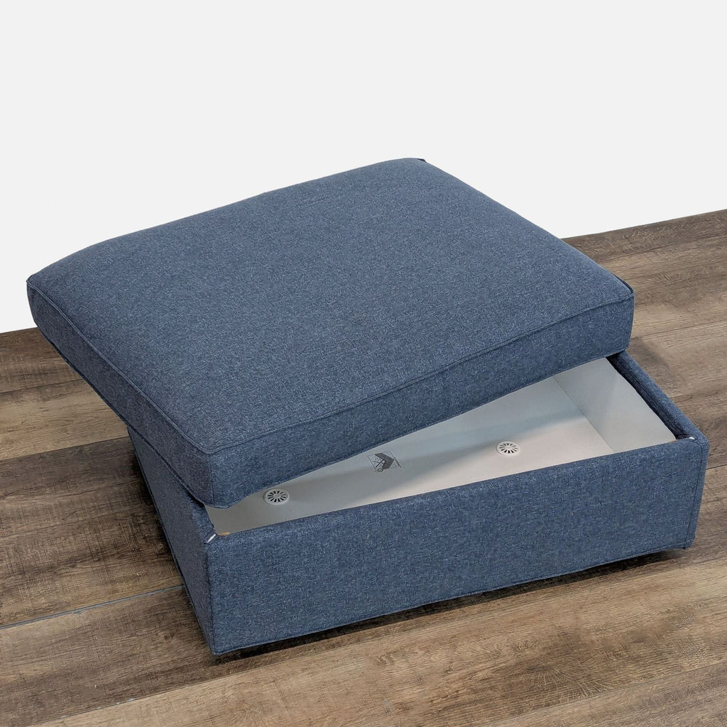3. Close-up of the blue Ikea Kivik ottoman opened to show its built-in storage compartment.