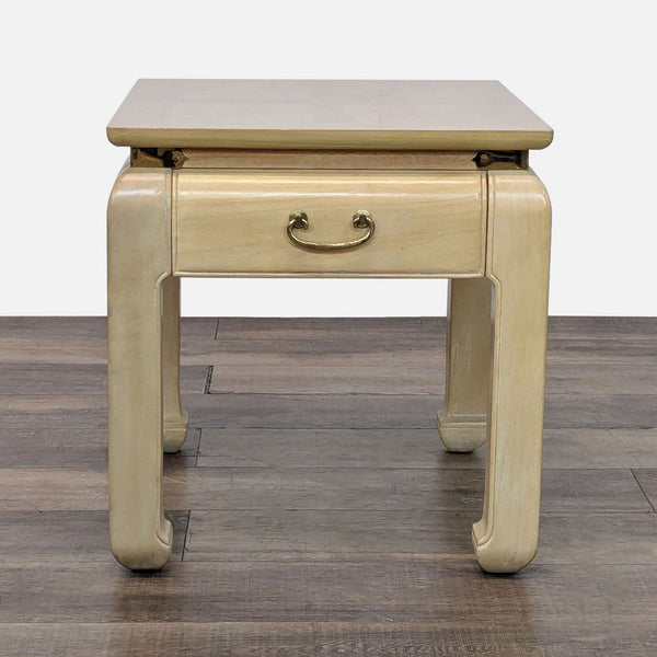 1. Bernhardt end table with cream lacquer finish and brass handle, featuring a closed single drawer.