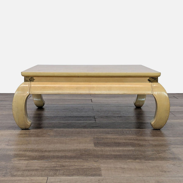 1. Bernhardt coffee table with cream lacquered finish, brass accents, and burl inlay top, curved legs visible.