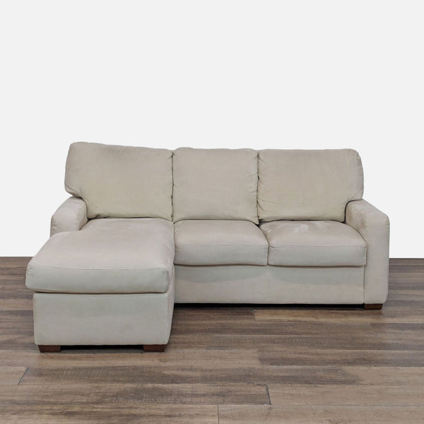 1. Front view of a beige American Upholstery sleeper sofa with chaise, storage, and Bella Suede Easy Care fabric.