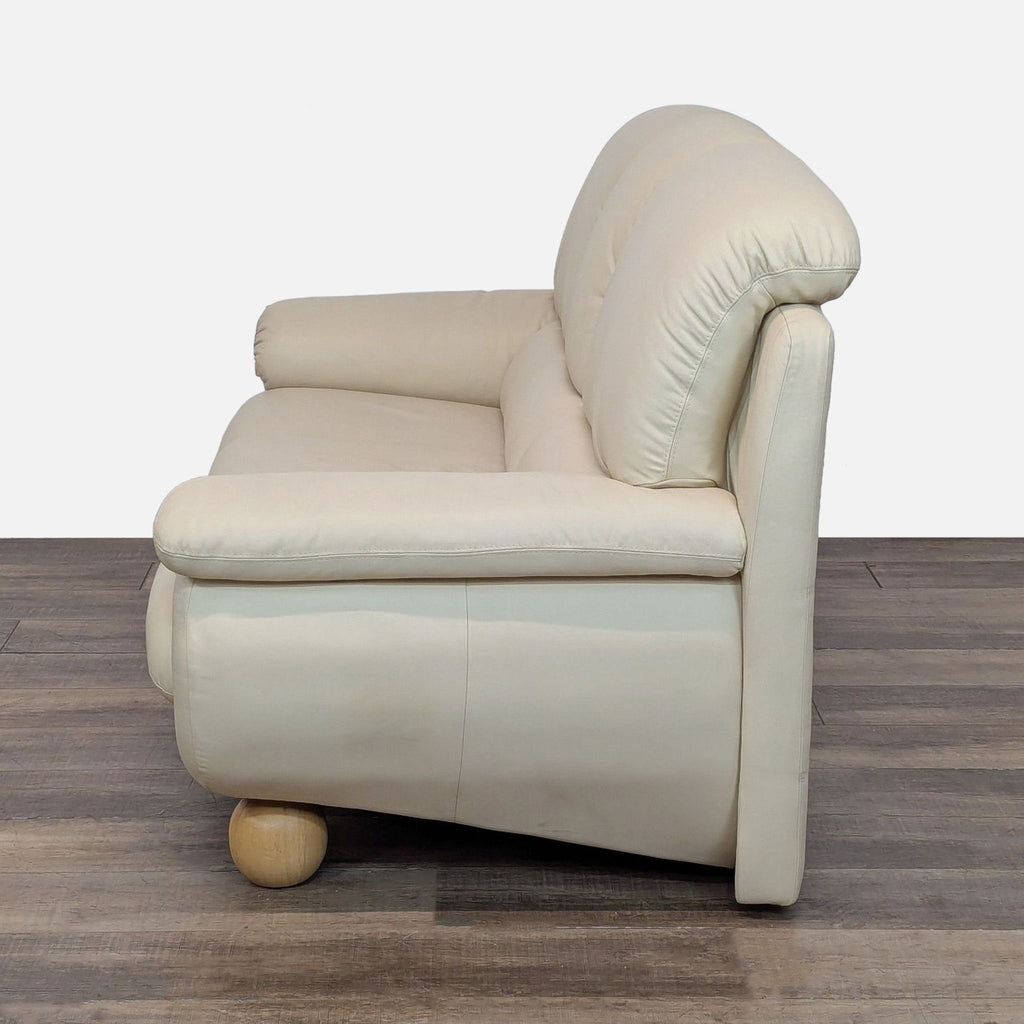 Reperch 3-seater sofa in cream leather, featuring plush seating, rounded arms, and stylish wooden ball legs, side angle.