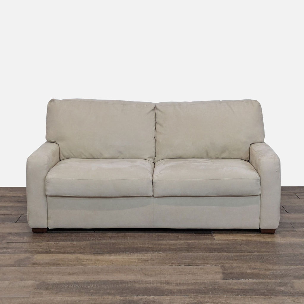 1. Beige Bella Suede loveseat sleeper sofa by American Upholstery, closed and sitting on a wooden floor.